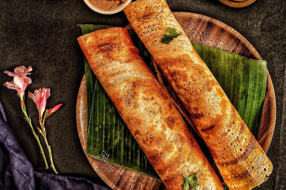 Crisp rolled dosas on a banana leaf